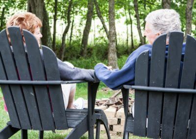 Couple holding hands in adirondack chairs